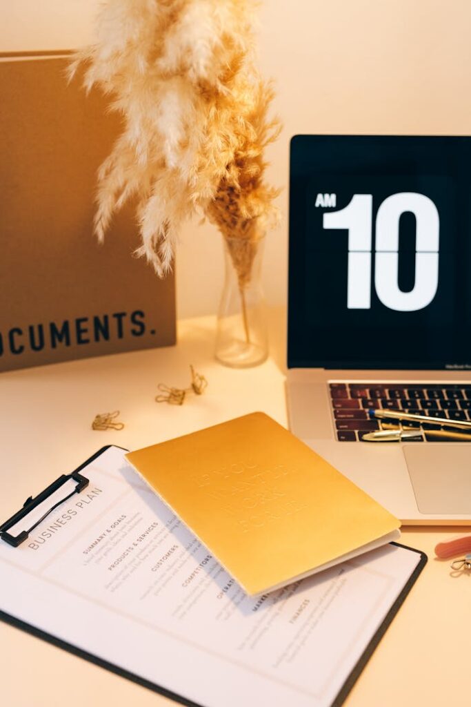 Modern business workspace with documents, a laptop, and a digital clock display.